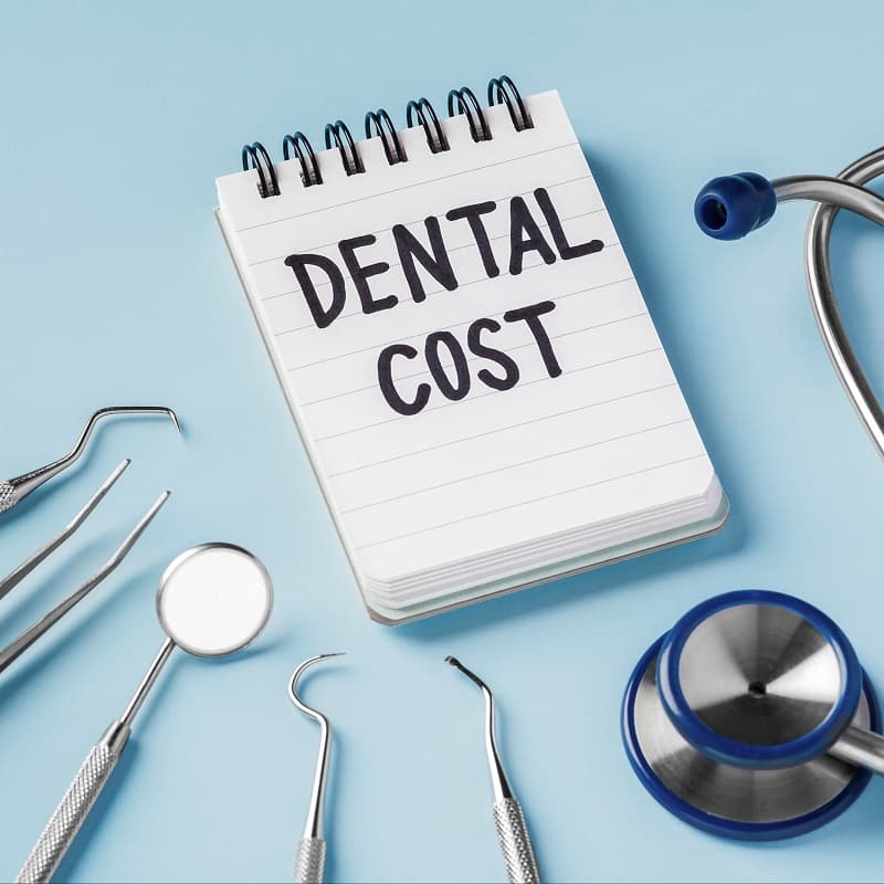 Dental care and treatment cost concept with dental instruments on blue background